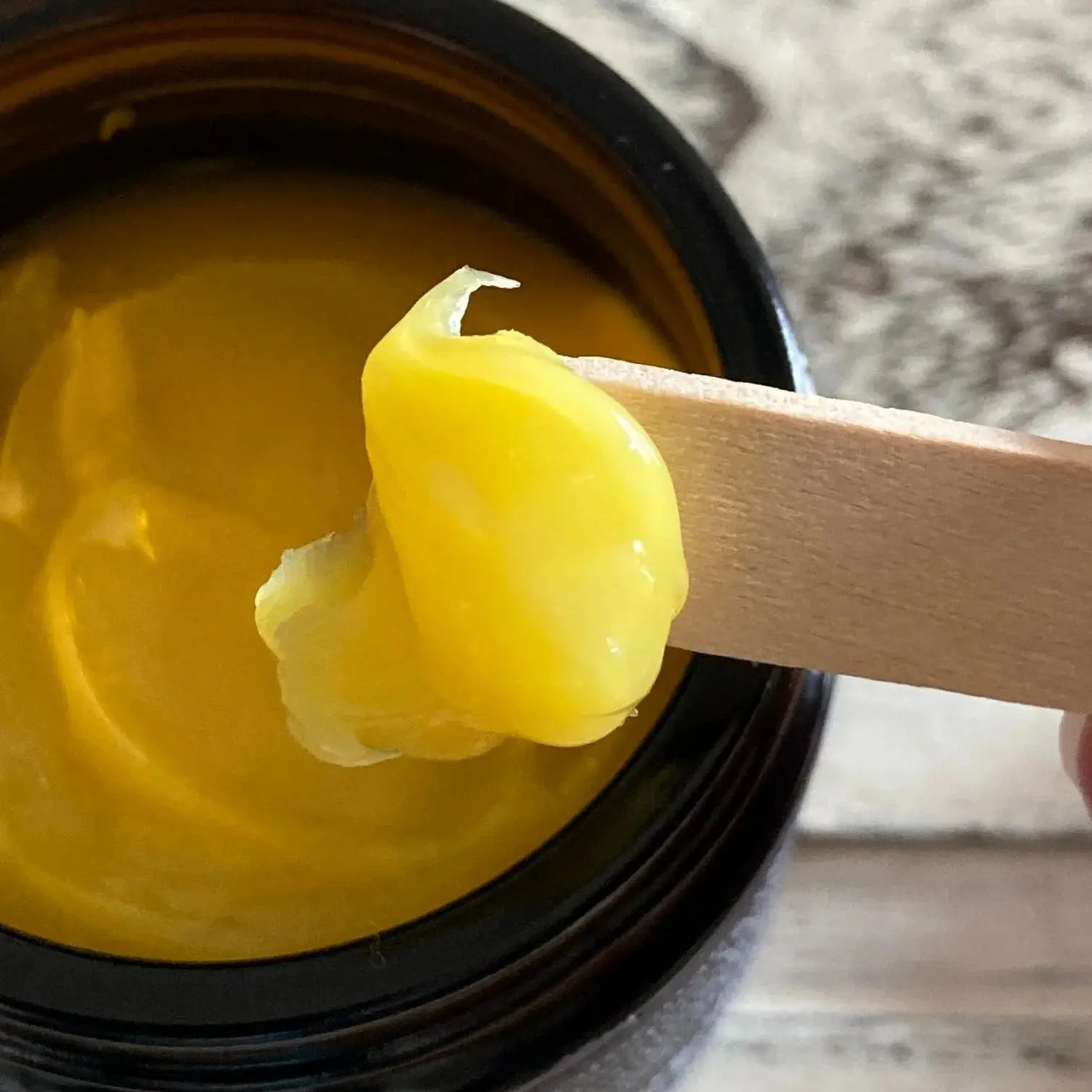 Yellow botanical balm in a jar with wooden spatula, Boo Cottage Botanicals skincare