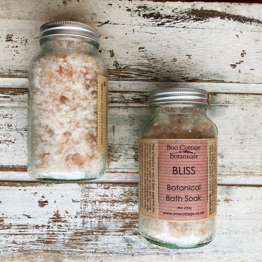 Pink labelled bottles of pink bath salt on whitewashed background