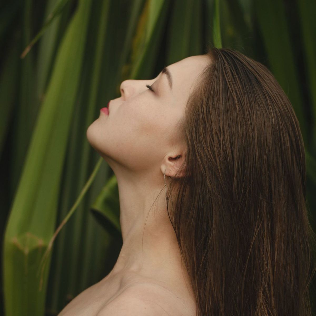 Brunette woman with straight hair on green background