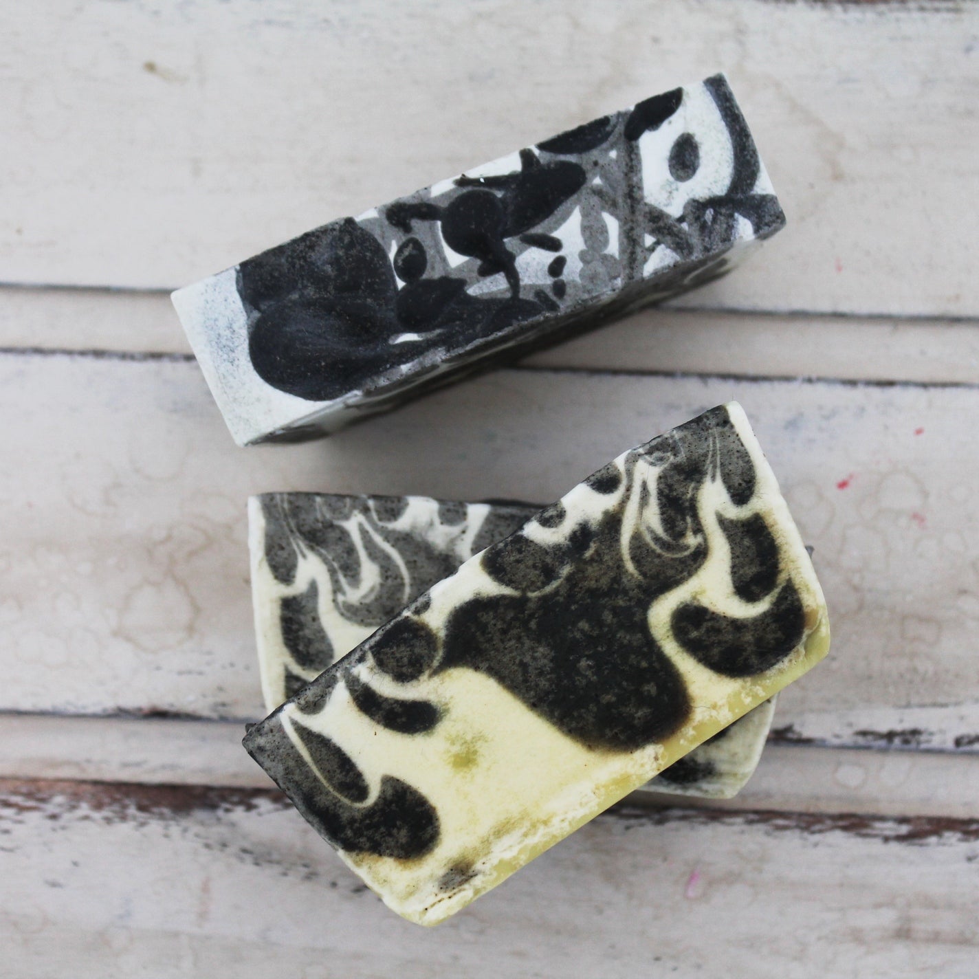 Black and cream swirled soap bars on whitewashed wooden background
