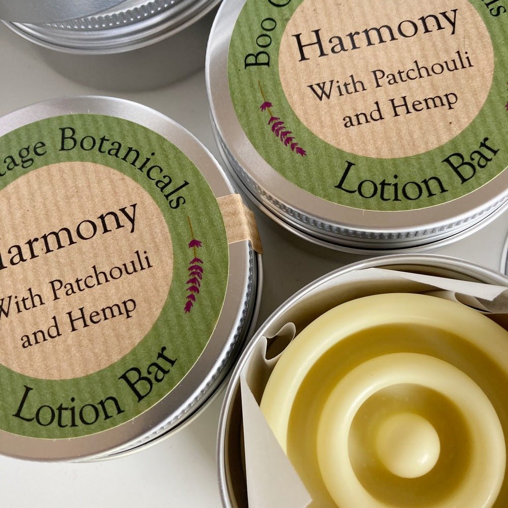 Tins of lotion bars with green labels and bar with concentric ring design on white background