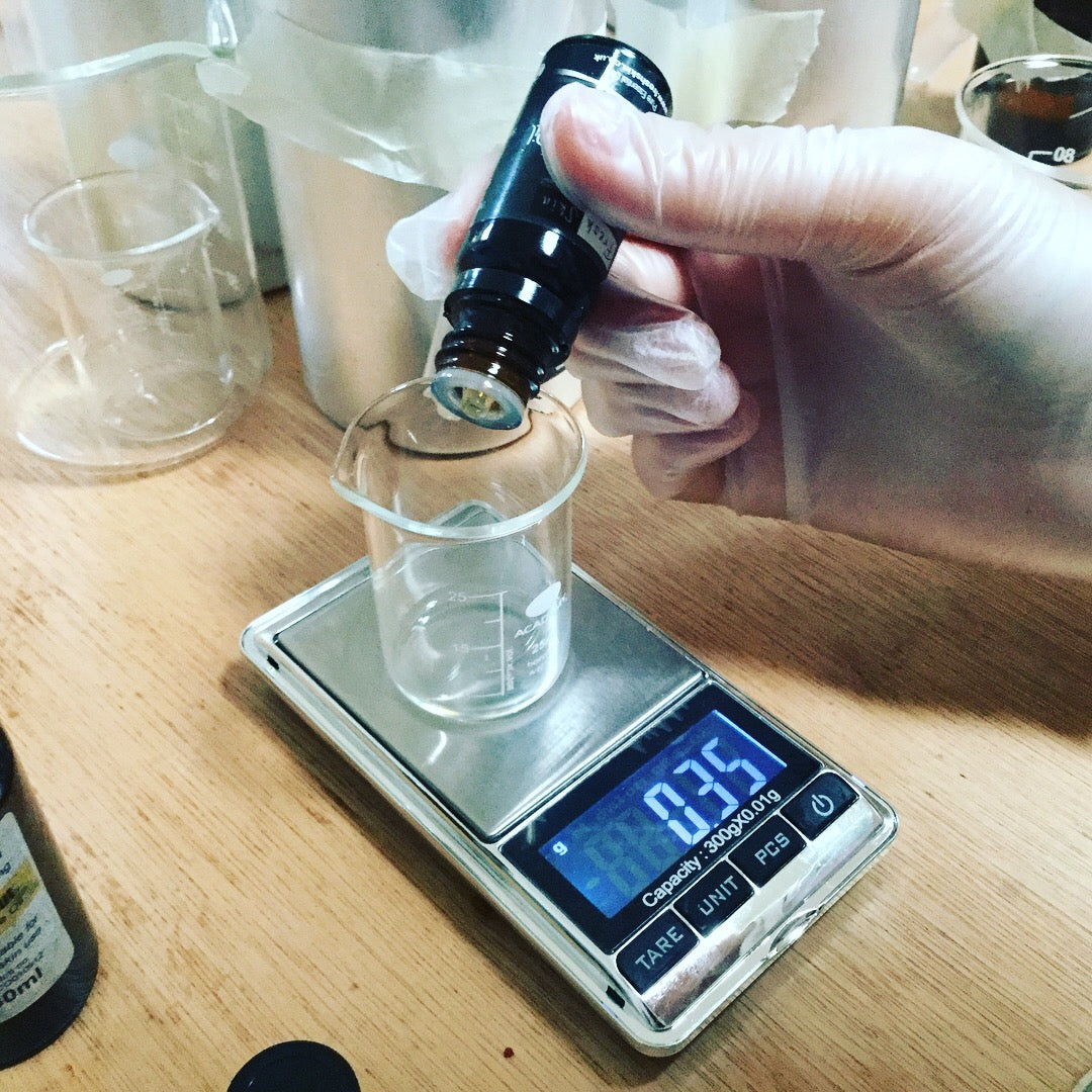 Weighing out essential oils into small beaker on tiny scales