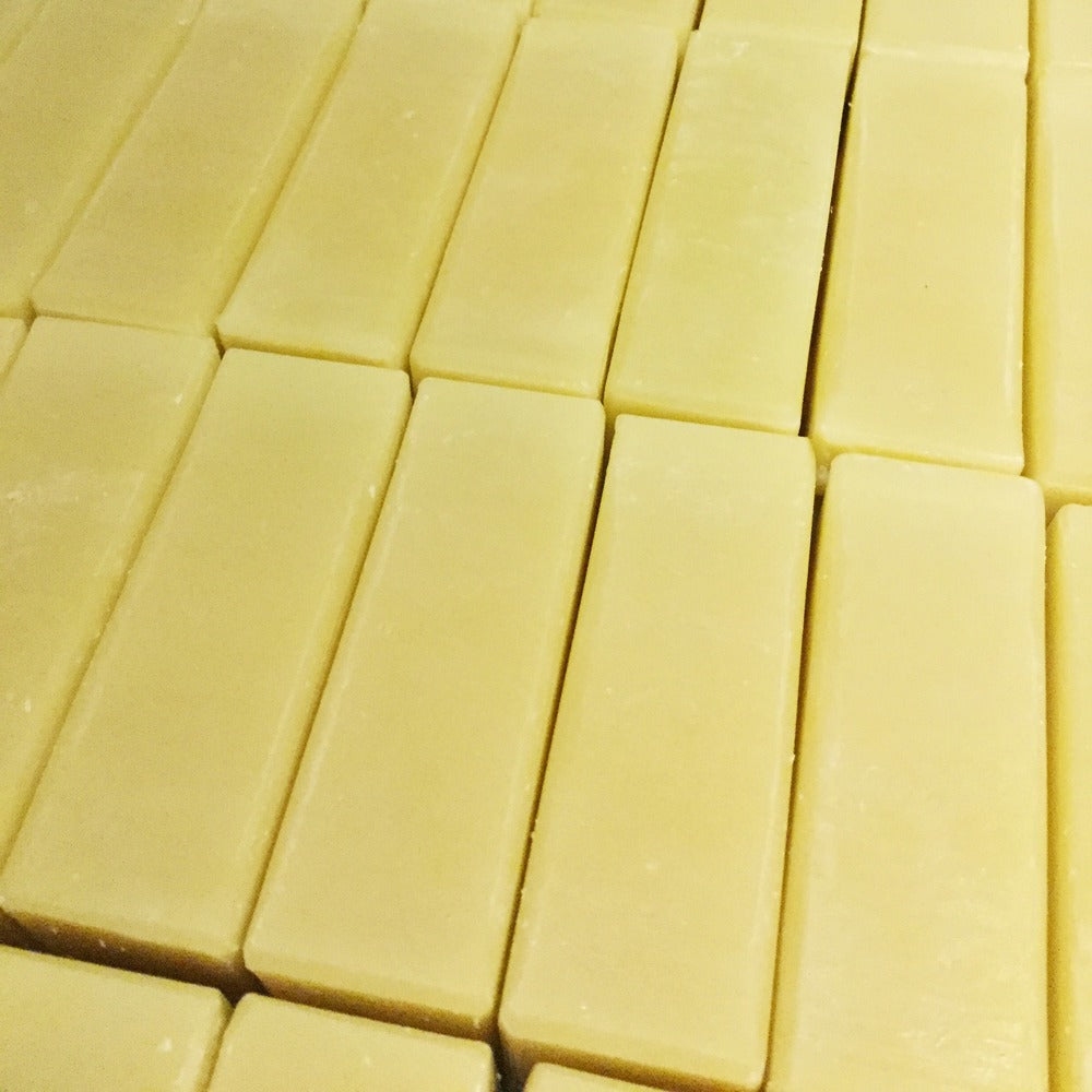 Collection of cream coloured soap all uniform sized bars next to each other