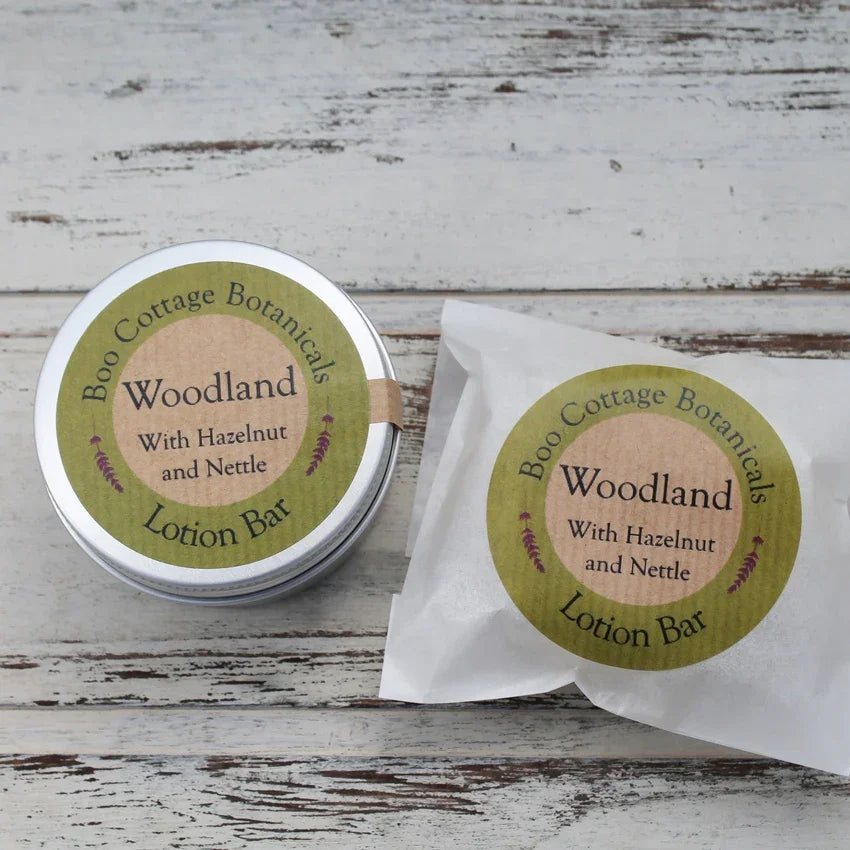 Round aluminium tin and waxed paper bag with green round stickers on whitewashed wooden background