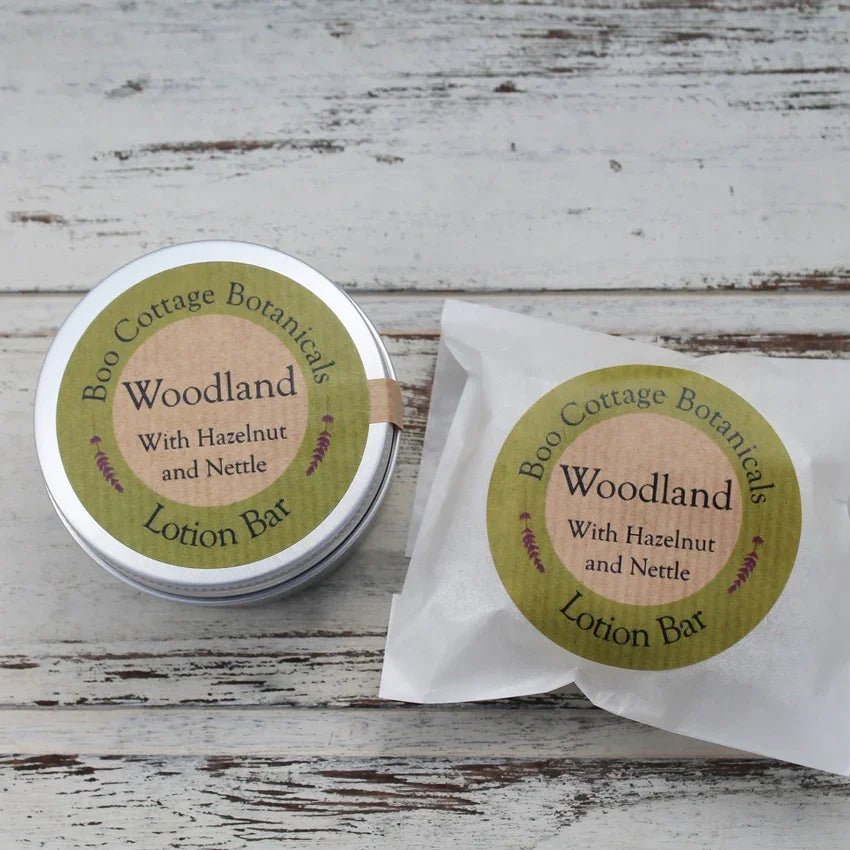 Round aluminium tin and waxed paper bag with green round stickers on whitewashed wooden background