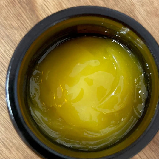 Natural botanical skincare balm in amber jar on wood surface by Boo Cottage Botanicals