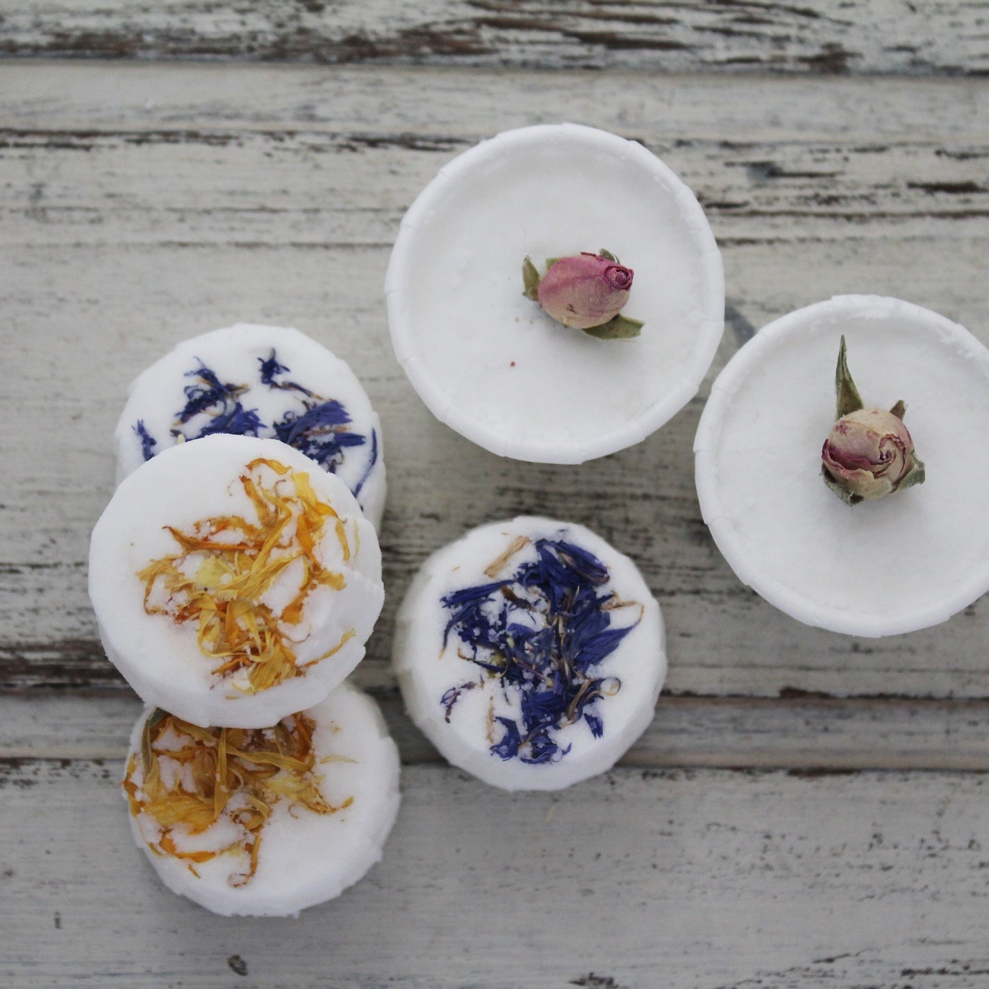 White bath truffles with dried flower tops on whitewashed wooden background