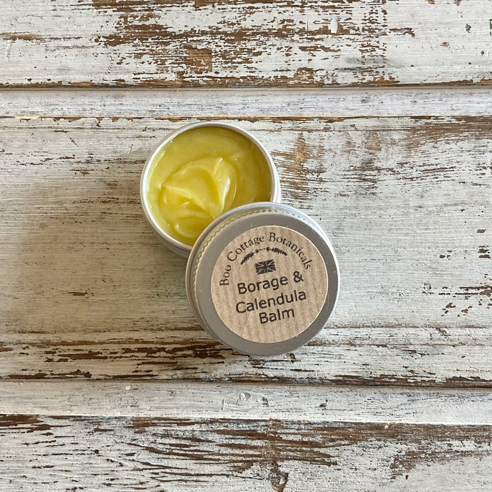 Yellow Borage and Calendula balm sample in mini aluminium tin on white background