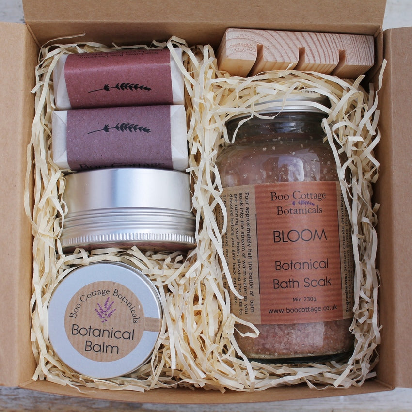 Open brown gift box showing pink and purple themed contents