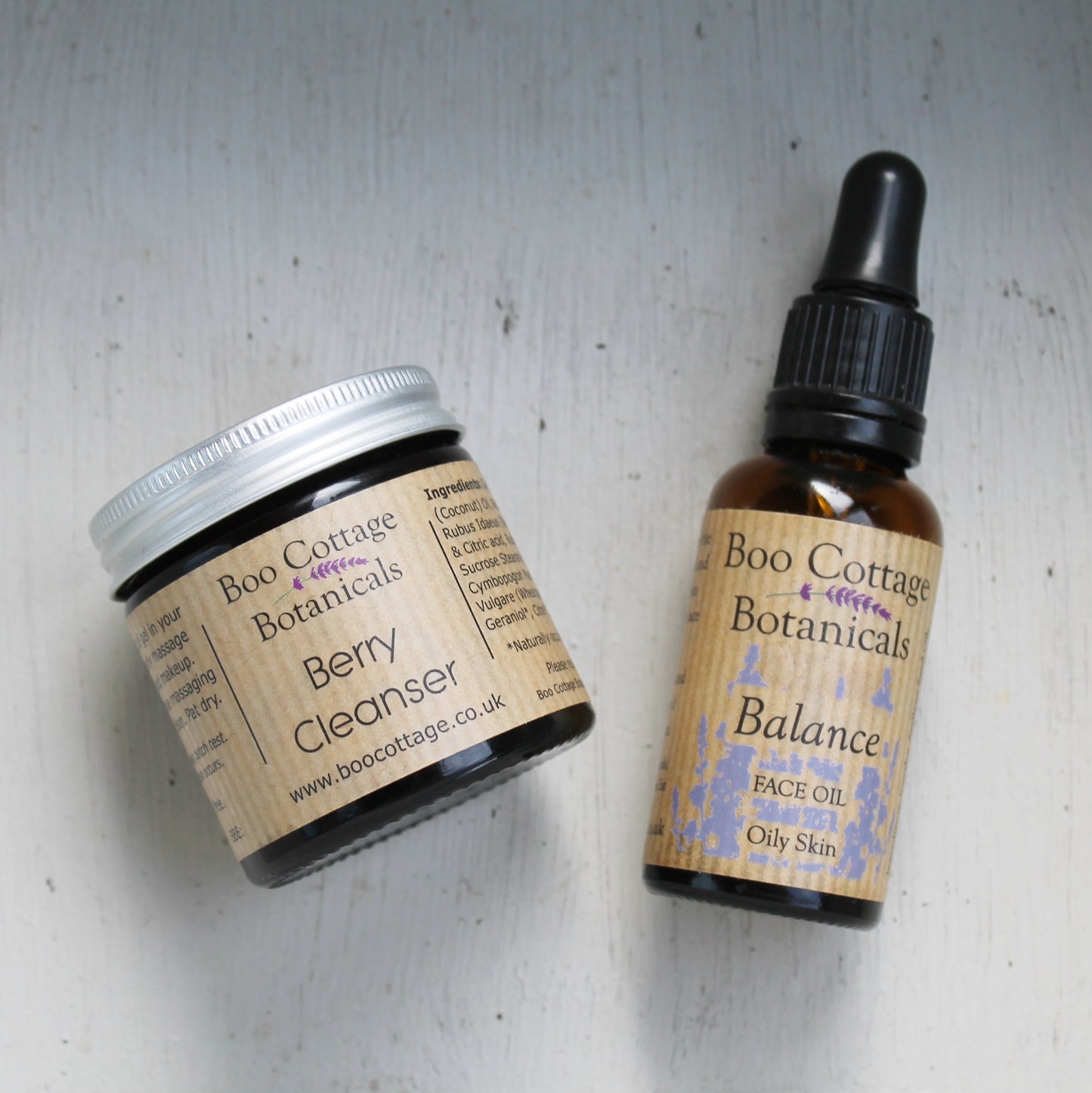 Berry cleanser and Balance face oil in amber jar and bottle on white painted background