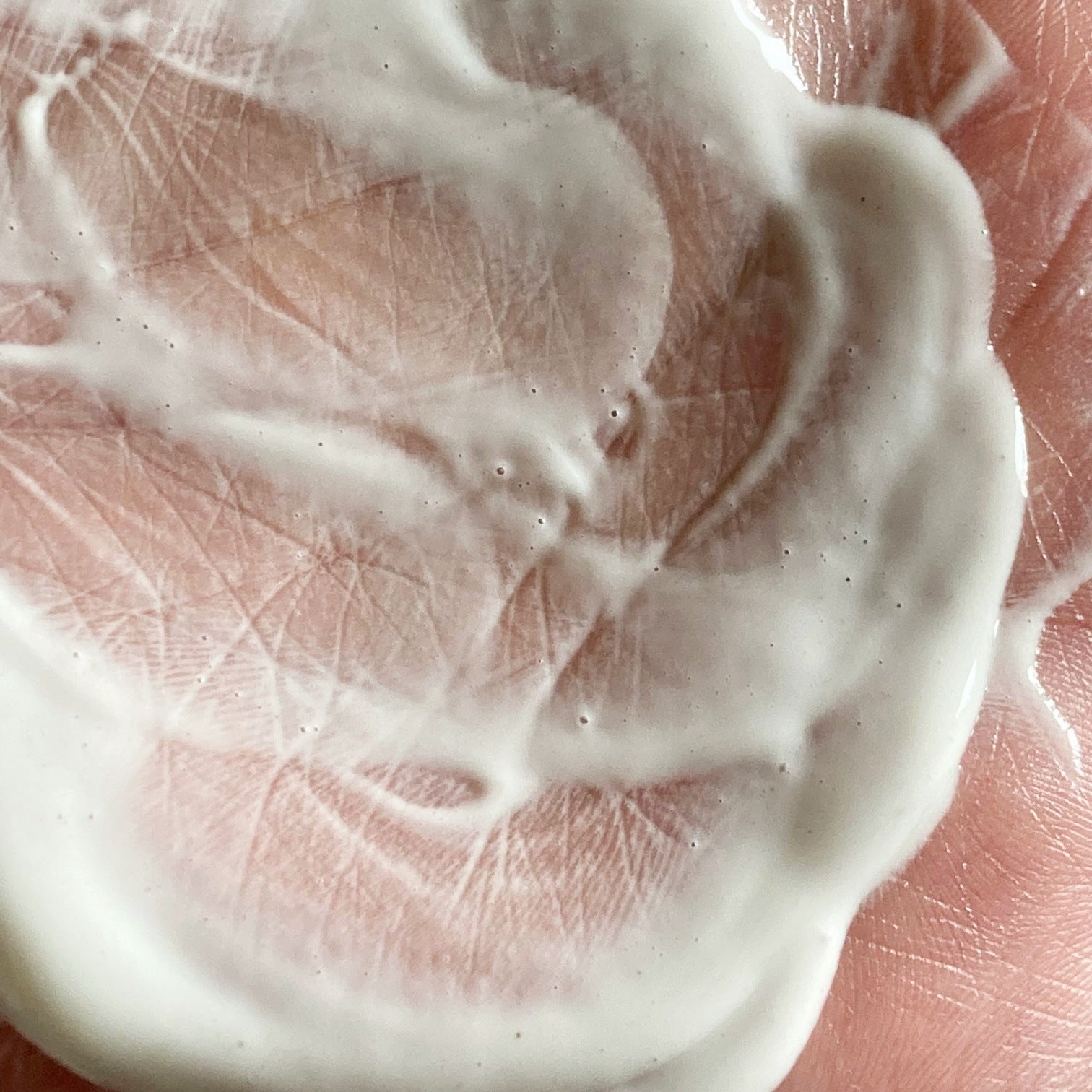 Close up of creamy white milky lotion on hand