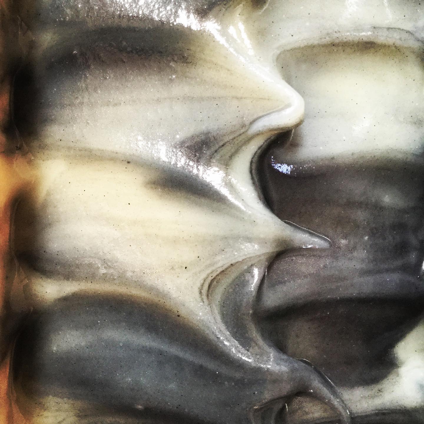 Glossy just poured texture of the top of a black and white marbled soap