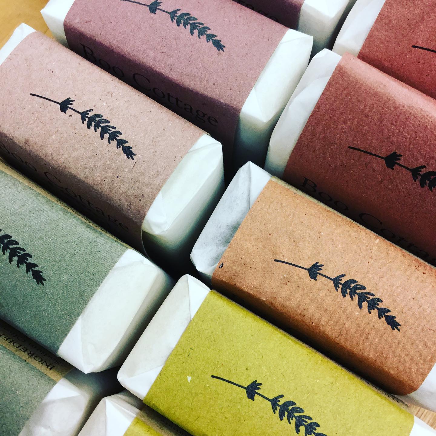 Close up of bars of soap wrapped in different coloured card each with a black lavender sprig logo on top