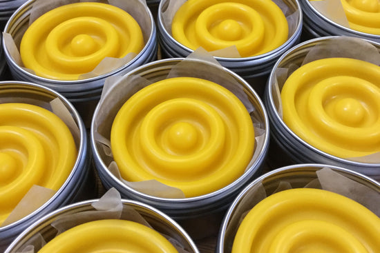 Yellow round lotion bars in alumionium tins