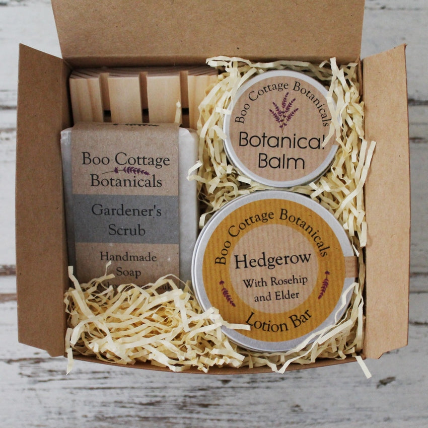 Selection of natural skincare products, soap, wooden soap dish in kraft card box with cream shredded paper