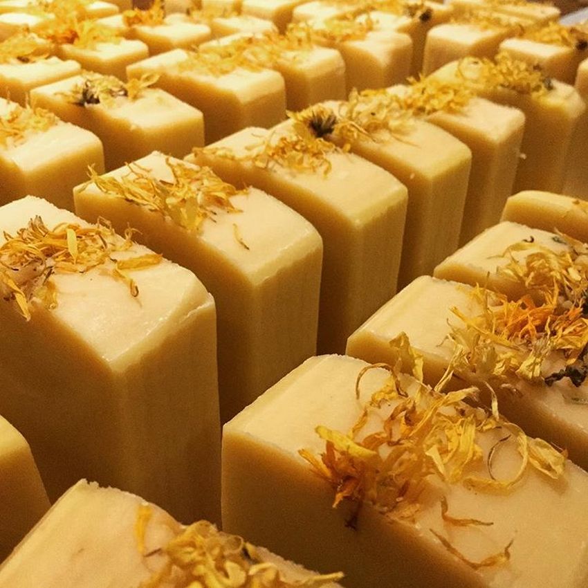 Collection of yellow soap bars with calendula toppings