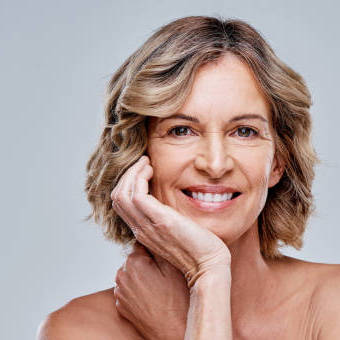 Mature white lady with medium length wavy hair and fine lines on face