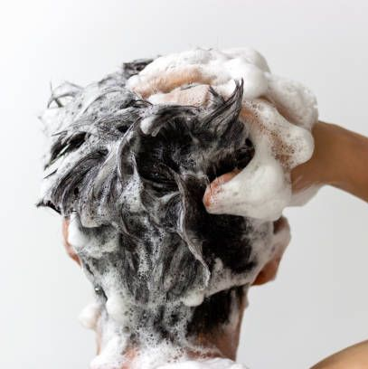 Shampoo bubbles being applied to brown hair