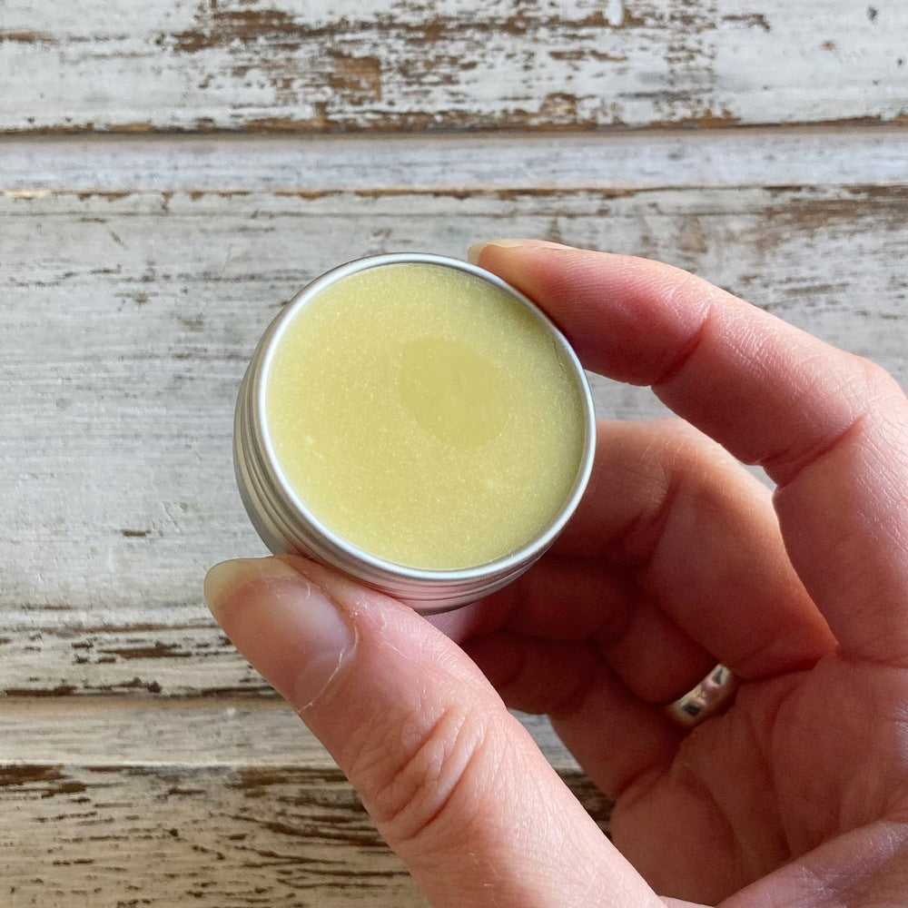 Cream Botanical Balm sample in aluminium mini tin in hand against white background