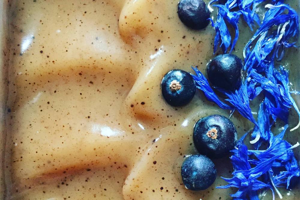 Close up of the top of a freshly poured Sunny Days soap with speckles, juniper berries and blue cornflowers